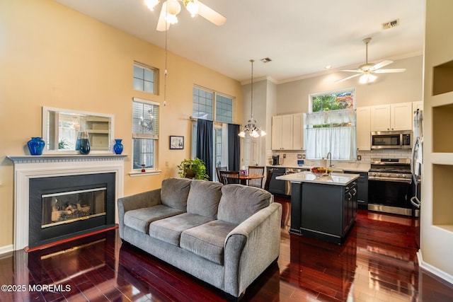 57 Mirage Blvd, Barnegat, NJ 08005 - living area with a ceiling fan, dark wood-style floors, a towering ceiling, a glass covered fireplace, and ornamental molding