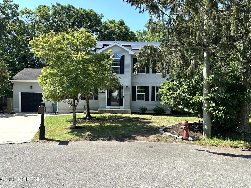 40 Saint Andrews Dr, Little Egg Harbor, NJ 08087 - view of front of home featuring a front yard, concrete driveway, roof mounted solar panels, and an attached garage