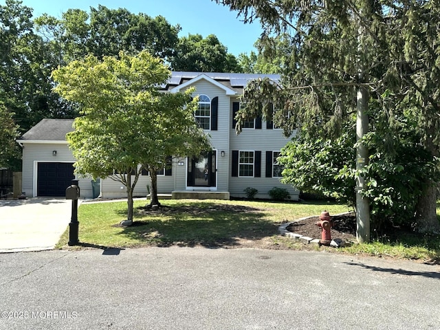40 Saint Andrews Dr, Little Egg Harbor, NJ 08087 - view of front of home featuring a front yard, concrete driveway, roof mounted solar panels, and an attached garage