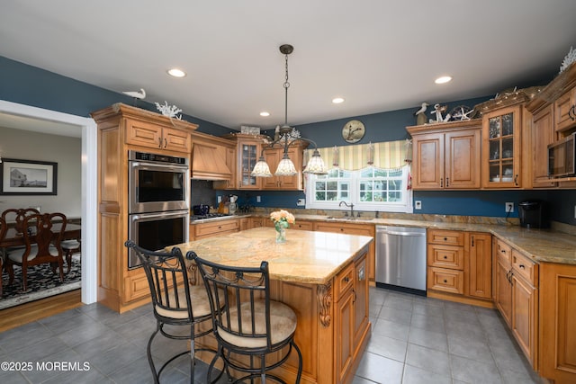 41 Cedar St, Keyport, NJ 07735 - kitchen with appliances with stainless steel finishes, a kitchen island, a kitchen bar, light stone countertops, and brown cabinets
