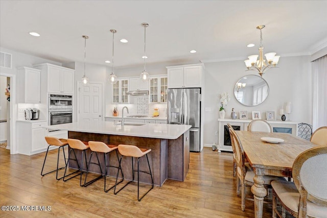 2 Lawley Dr, Lincroft, NJ 07738 - kitchen featuring stainless steel appliances, decorative backsplash, an island with sink, light wood-type flooring, and recessed lighting
