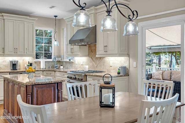 45 Erin Dr, Jackson, NJ 08527 - kitchen featuring wall chimney range hood, backsplash, hanging light fixtures, and light stone countertops