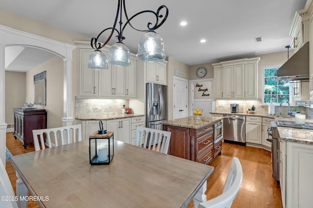 45 Erin Dr, Jackson, NJ 08527 - kitchen featuring appliances with stainless steel finishes, a center island, arched walkways, backsplash, and under cabinet range hood