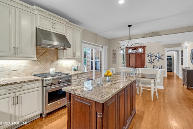 45 Erin Dr, Jackson, NJ 08527 - kitchen with high end stainless steel range oven, under cabinet range hood, light wood-style flooring, and arched walkways