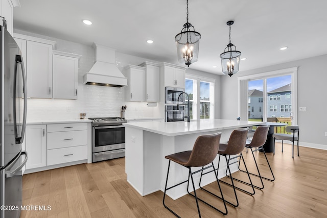 3 Devon Dr, Howell, NJ 07731 - kitchen with appliances with stainless steel finishes, custom range hood, light countertops, light wood-style flooring, and tasteful backsplash