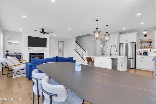 3 Devon Dr, Howell, NJ 07731 - dining room with ceiling fan, light wood finished floors, recessed lighting, a warm lit fireplace, and stairs