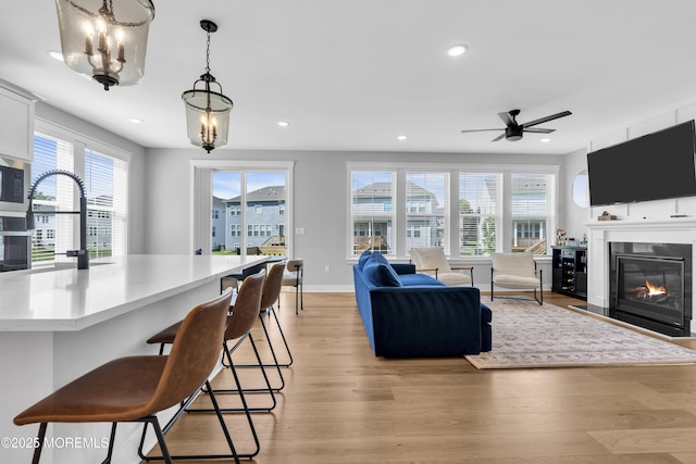 3 Devon Dr, Howell, NJ 07731 - living area featuring light wood-type flooring, healthy amount of natural light, recessed lighting, a glass covered fireplace, and a chandelier