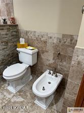 33 Tennent Ave, Englishtown, NJ 07726 - bathroom with tile walls, a bidet, and a wainscoted wall