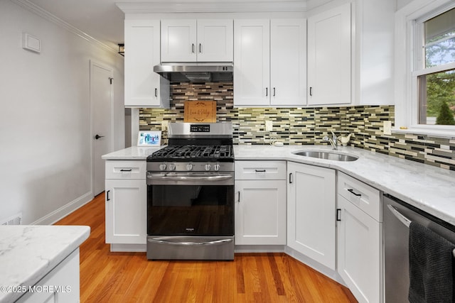 2120 Frances Dr, Point Pleasant, NJ 08742 - kitchen with appliances with stainless steel finishes, under cabinet range hood, ornamental molding, white cabinets, and tasteful backsplash