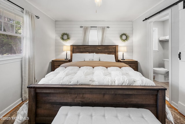 2120 Frances Dr, Point Pleasant, NJ 08742 - bedroom featuring a barn door, wood finished floors, ensuite bath, and wooden walls