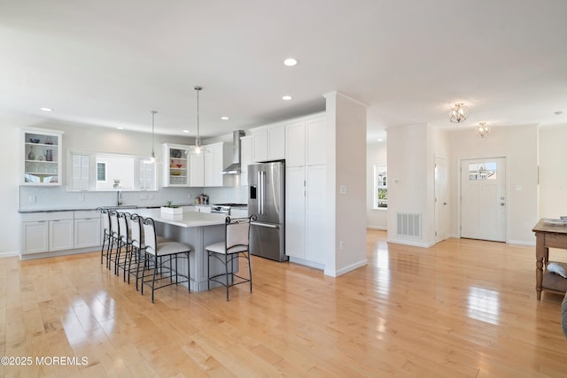 1735 Certainty Dr, Point Pleasant, NJ 08742 - kitchen with stainless steel appliances, wall chimney range hood, a kitchen breakfast bar, white cabinets, and recessed lighting