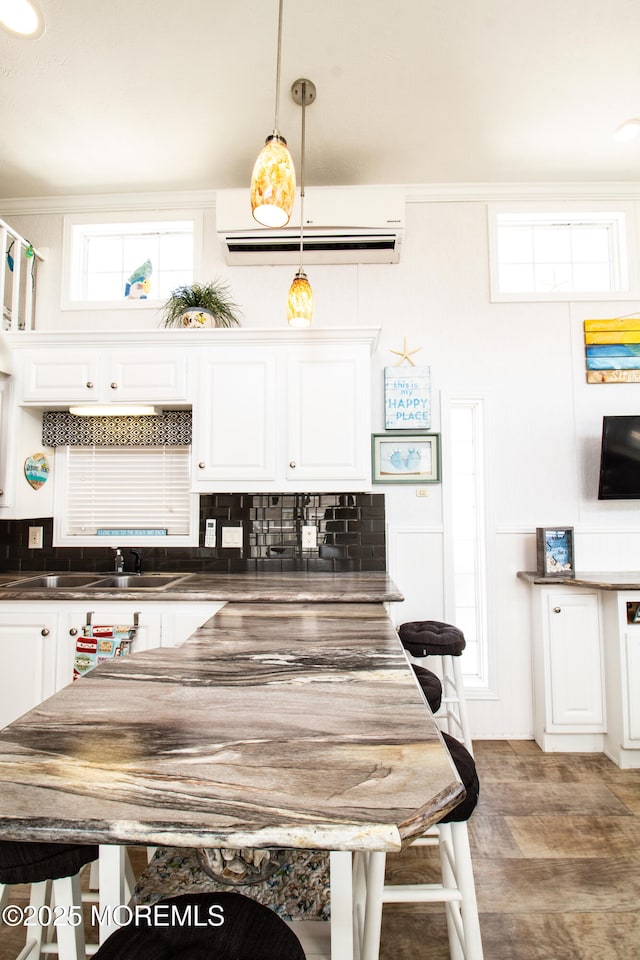 37 15th Ave, Seaside Park, NJ 08752 - kitchen with a wall unit AC, dark countertops, white cabinets, tasteful backsplash, and decorative light fixtures