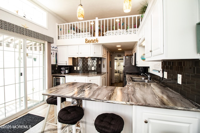 37 15th Ave, Seaside Park, NJ 08752 - kitchen featuring a peninsula, decorative backsplash, white cabinets, a high ceiling, and dark stone countertops