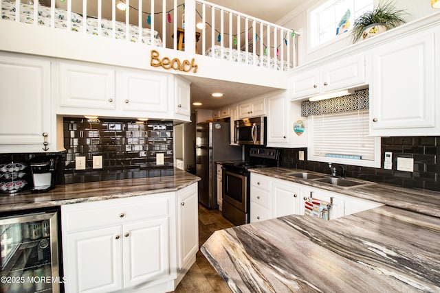 37 15th Ave, Seaside Park, NJ 08752 - kitchen with appliances with stainless steel finishes, beverage cooler, backsplash, and white cabinets