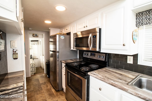 37 15th Ave, Seaside Park, NJ 08752 - kitchen featuring appliances with stainless steel finishes, white cabinets, dark wood-style flooring, tasteful backsplash, and recessed lighting