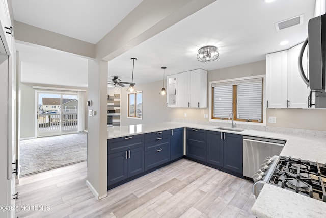 4 W Shrewsbury Dr, Little Egg Harbor, NJ 08087 - kitchen with stainless steel appliances, white cabinets, light countertops, a peninsula, and light wood-style flooring