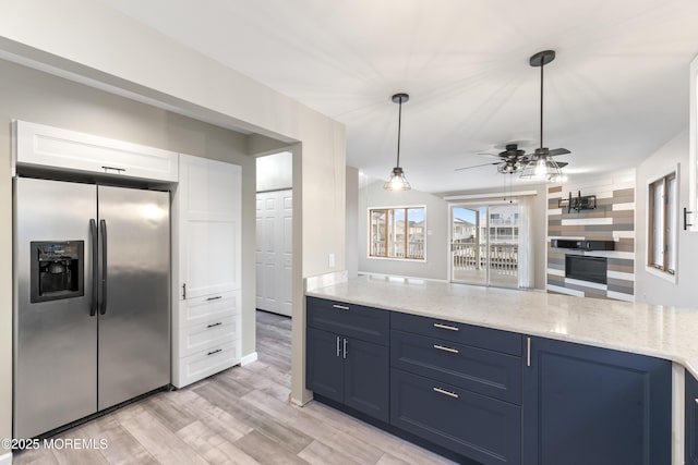 4 W Shrewsbury Dr, Little Egg Harbor, NJ 08087 - kitchen with stainless steel fridge, light stone countertops, light wood finished floors, a ceiling fan, and blue cabinetry