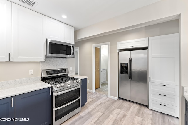 4 W Shrewsbury Dr, Little Egg Harbor, NJ 08087 - kitchen with stainless steel appliances, blue cabinets, white cabinets, light wood finished floors, and recessed lighting