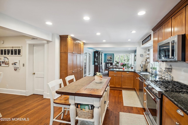 34 Sea View Ter, Highlands, NJ 07732 - kitchen featuring appliances with stainless steel finishes, dark wood-style floors, a peninsula, brown cabinetry, and recessed lighting
