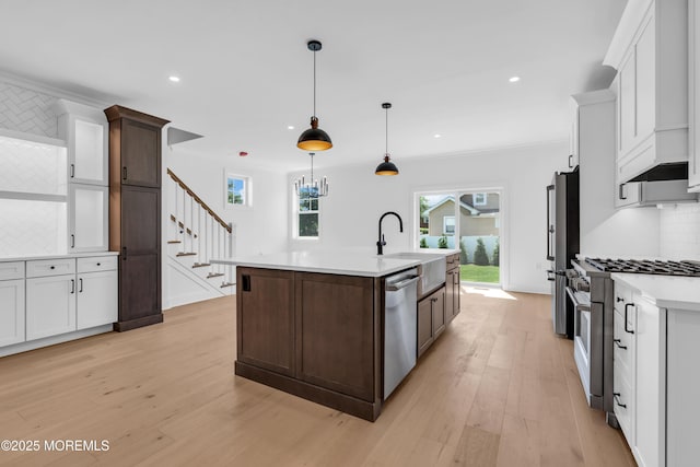 842 Arnold Ave Unit 4, Point Pleasant, NJ 08742 - kitchen with stainless steel appliances, decorative backsplash, light countertops, light wood finished floors, and a kitchen island with sink