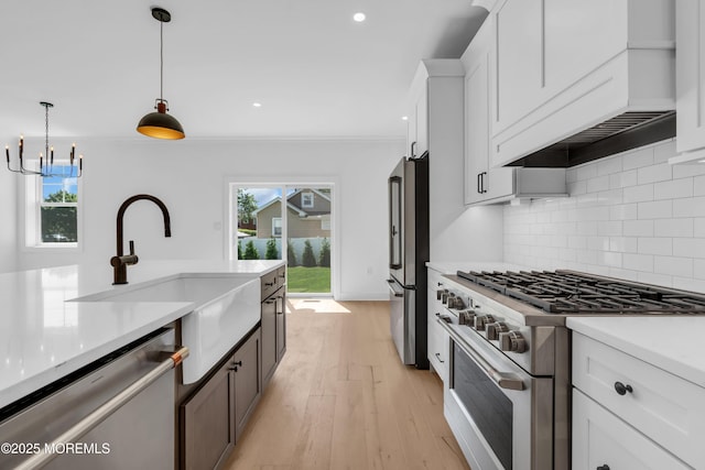 842 Arnold Ave Unit 4, Point Pleasant, NJ 08742 - kitchen featuring appliances with stainless steel finishes, light countertops, backsplash, hanging light fixtures, and white cabinets