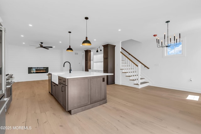 842 Arnold Ave Unit 4, Point Pleasant, NJ 08742 - kitchen featuring open floor plan, light wood-style flooring, a glass covered fireplace, light countertops, and a chandelier
