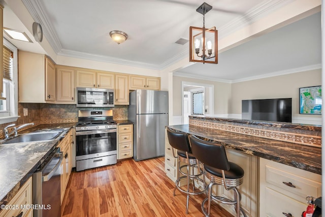 13 Brooke Rd, Brick, NJ 08724 - kitchen featuring appliances with stainless steel finishes, light wood-style floors, ornamental molding, cream cabinets, and decorative backsplash
