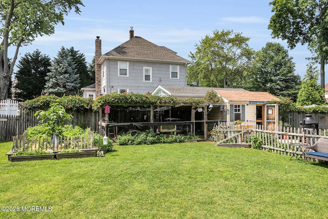 216 Main St, Port Monmouth, NJ 07758 - back of property with a vegetable garden, a chimney, a fenced backyard, and roof with shingles