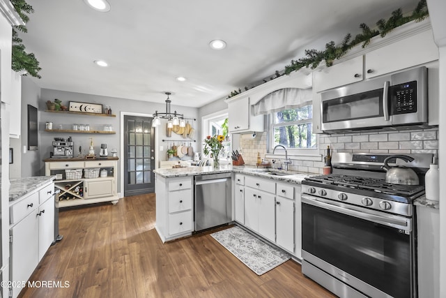 91 Newbury Rd, Howell, NJ 07731 - kitchen with stainless steel appliances, white cabinetry, a peninsula, a chandelier, and backsplash