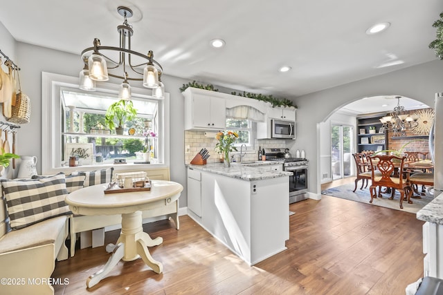 91 Newbury Rd, Howell, NJ 07731 - kitchen featuring stainless steel appliances, a chandelier, arched walkways, backsplash, and white cabinetry