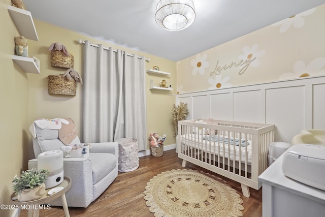 91 Newbury Rd, Howell, NJ 07731 - bedroom featuring wood finished floors, a crib, and a decorative wall