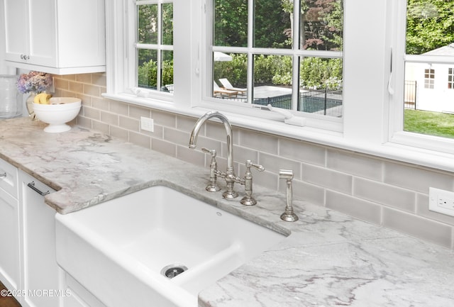 63 Bingham Ave, Rumson, NJ 07760 - kitchen view of decorative backsplash, white cabinetry, and light stone counters