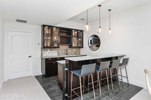 63 Bingham Ave, Rumson, NJ 07760 - indoor wet bar with tasteful backsplash, dark wood finished floors, and pendant lighting