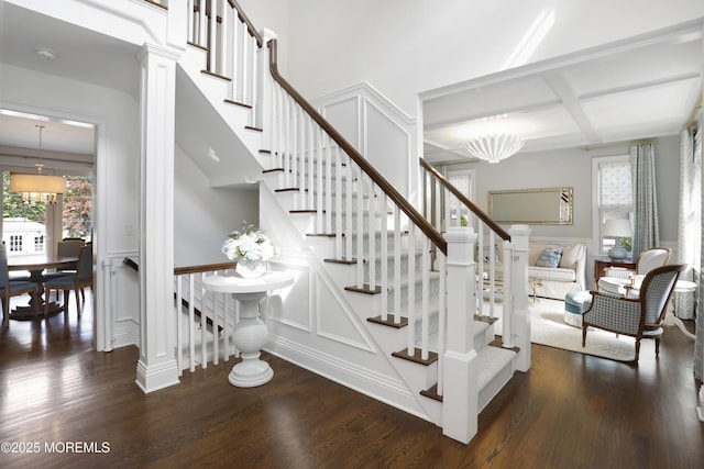 63 Bingham Ave, Rumson, NJ 07760 - stairway featuring coffered ceiling, a decorative wall, wood finished floors, beamed ceiling, and a wainscoted wall