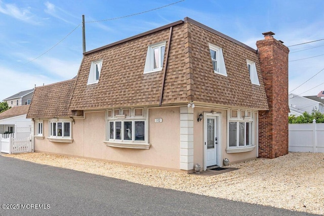 102 W Colony Rd, Lavallette, NJ 08735 - view of front facade with mansard roof, roof with shingles, stucco siding, and a chimney