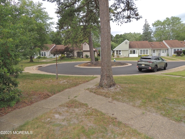 455A Chesterfield Ct, Manchester, NJ 08759 - view of green lawn featuring curved driveway and a residential view