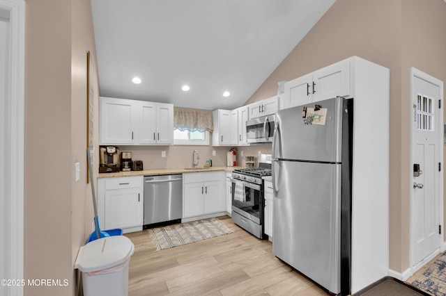 241 Hiering Ave, Seaside Heights, NJ 08751 - kitchen featuring appliances with stainless steel finishes, light wood finished floors, white cabinets, lofted ceiling, and recessed lighting