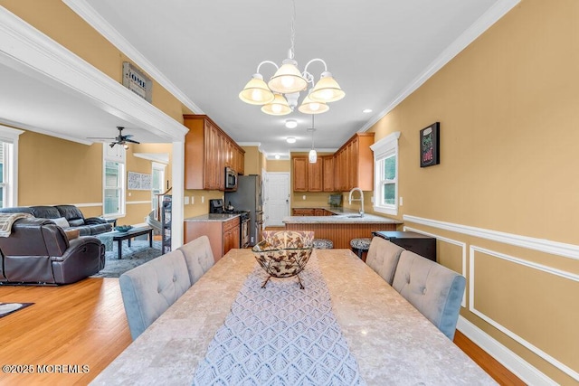 626 Anthony Ave, Toms River, NJ 08753 - dining room featuring ornamental molding, a chandelier, light wood finished floors, ceiling fan, and a wainscoted wall
