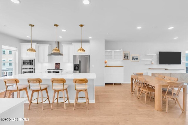 25 Signal Ave, Oceanport, NJ 07757 - kitchen with appliances with stainless steel finishes, wall chimney exhaust hood, white cabinets, tasteful backsplash, and light countertops