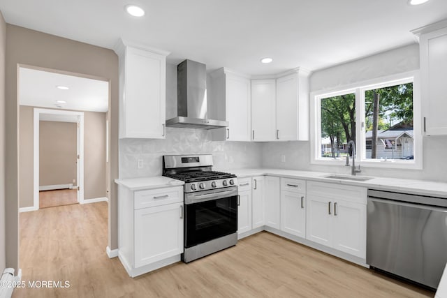 30 Stuyvesant Rd, Brick, NJ 08723 - kitchen featuring stainless steel appliances, wall chimney exhaust hood, light wood-type flooring, white cabinetry, and recessed lighting