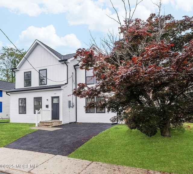 131 3rd St, Keyport, NJ 07735 - view of front facade with asphalt driveway, board and batten siding, and a front yard