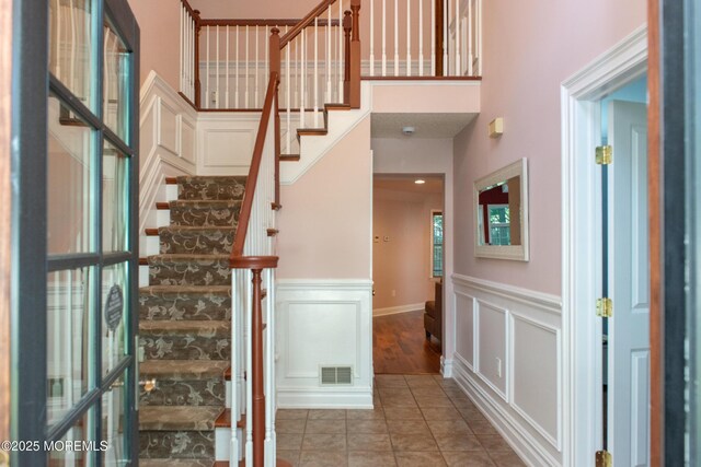 223 Kelly Lynn Ln, Brick, NJ 08724 - stairs featuring tile patterned flooring, a wainscoted wall, a high ceiling, and a decorative wall
