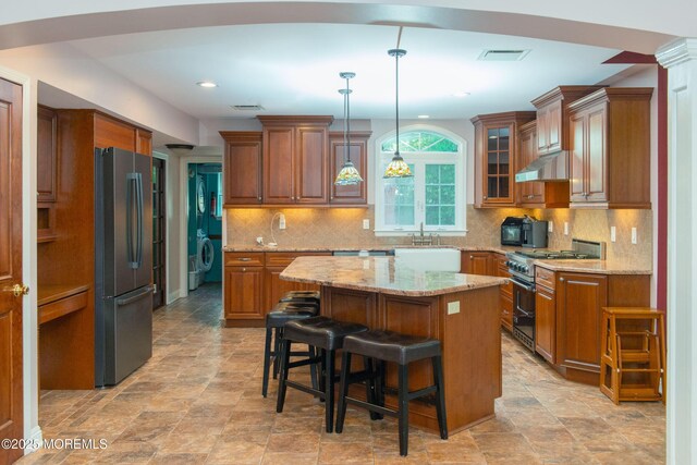 223 Kelly Lynn Ln, Brick, NJ 08724 - kitchen featuring appliances with stainless steel finishes, brown cabinetry, under cabinet range hood, and recessed lighting