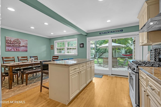384 Gerry Rd, North Brunswick, NJ 08902 - kitchen with stainless steel range with gas stovetop, wall chimney range hood, crown molding, cream cabinets, and light wood-style floors