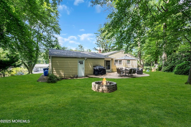 384 Gerry Rd, North Brunswick, NJ 08902 - rear view of house with a patio, a yard, a chimney, and an outdoor living space with a fire pit