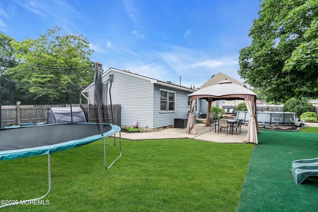 1425 Birmingham Ave, Toms River, NJ 08757 - back of property with a trampoline, a fenced backyard, a patio, a gazebo, and a chimney