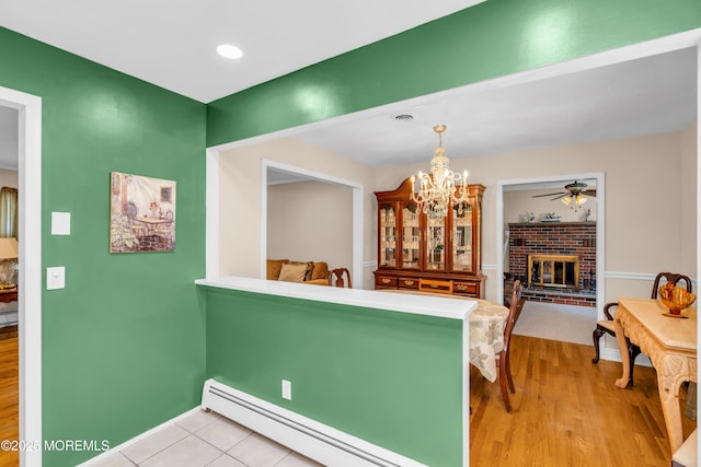 106 Northumberland Dr, Toms River, NJ 08757 - dining area featuring a chandelier, light wood-type flooring, a baseboard radiator, a ceiling fan, and a fireplace
