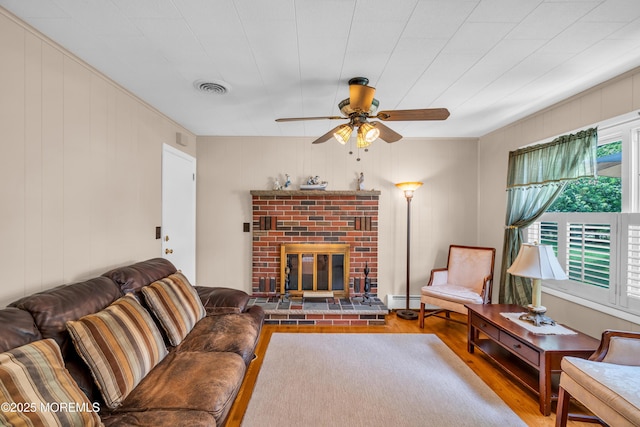 106 Northumberland Dr, Toms River, NJ 08757 - living room with wood finished floors, a ceiling fan, a brick fireplace, baseboard heating, and wooden walls