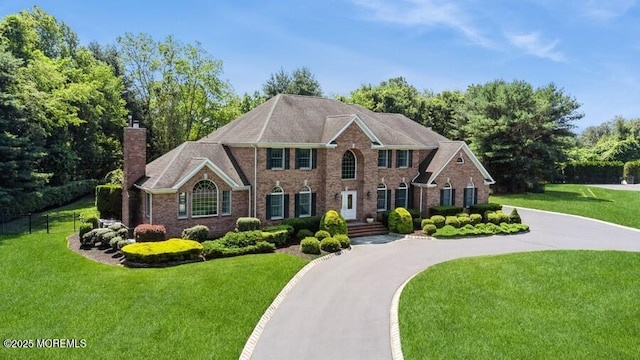9 Wide Horizons Dr, Colts Neck, NJ 07722 - georgian-style home with a chimney, a front lawn, and brick siding