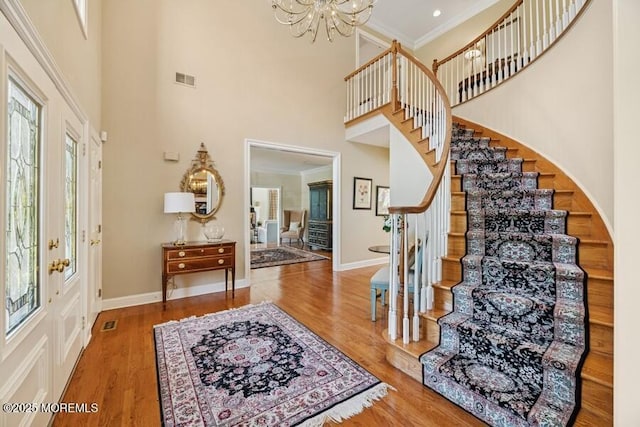 9 Wide Horizons Dr, Colts Neck, NJ 07722 - entryway with a towering ceiling, stairs, a chandelier, wood finished floors, and crown molding